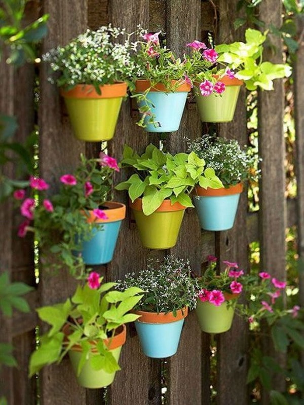 Coloured pots hanging from wooden pallets