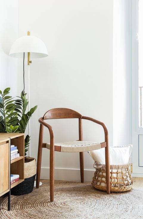 reading corner with wooden chair, white floor lamp and a basket of natural fibres