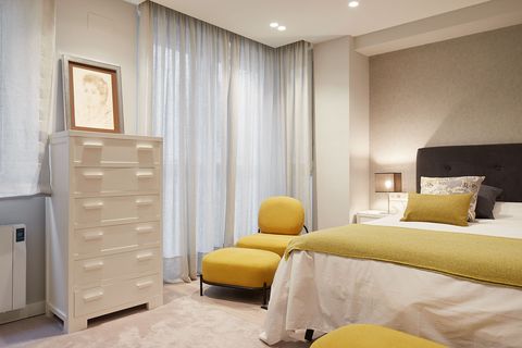 modern bedroom decorated in neutral tones with mustard details