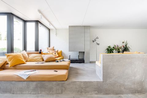 living room with concrete floor and sofa structure and orange seats