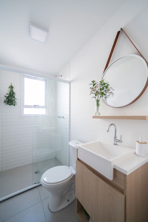 bathroom decorated in white with wooden furniture and plants
