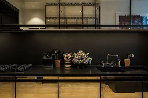 contemporary kitchen with black front and aged mirrors on the cabinet doors