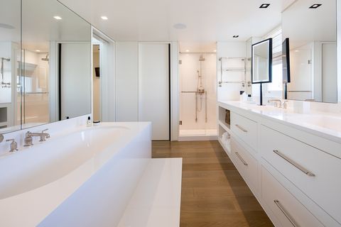 bathroom decorated in white with bathtub and shower at floor level