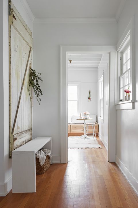 hallway decorated with old barn door and white shoe bench