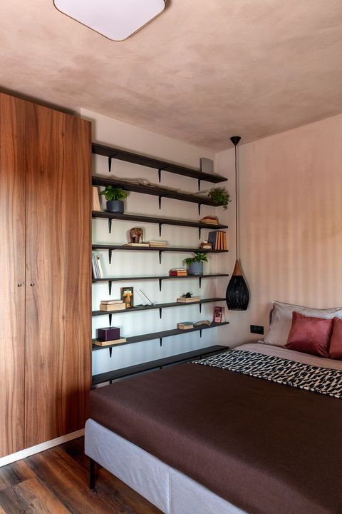 bedroom decorated in earth tones with open bookcase
