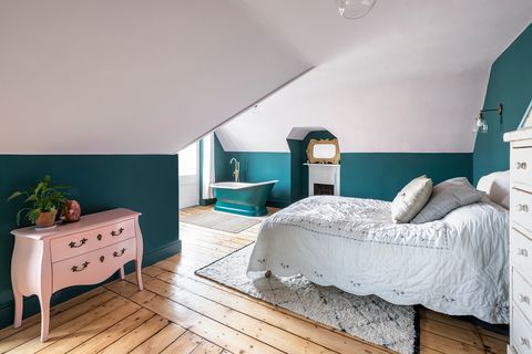 bedroom with freestanding bathtub and vintage dresser in pink
