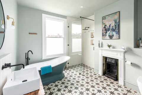 vintage bathroom with fireplace, classic freestanding bathtub and hydraulic tile floor