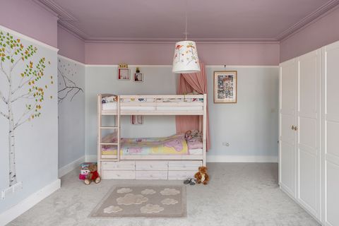 kids bedroom with bunk bed and tree patterned mural on the wall