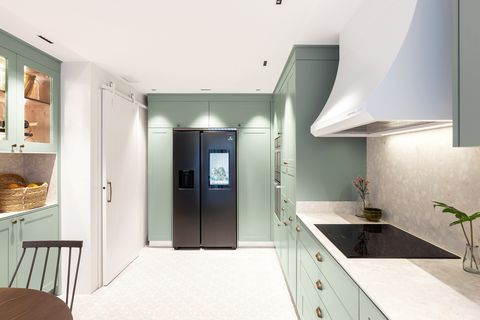 Provençal style office kitchen with dusty green cabinets and stainless steel fridge