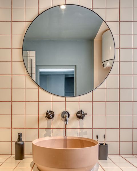 a cool vintage apartment in barcelona bathroom with freestanding sink and round mirror