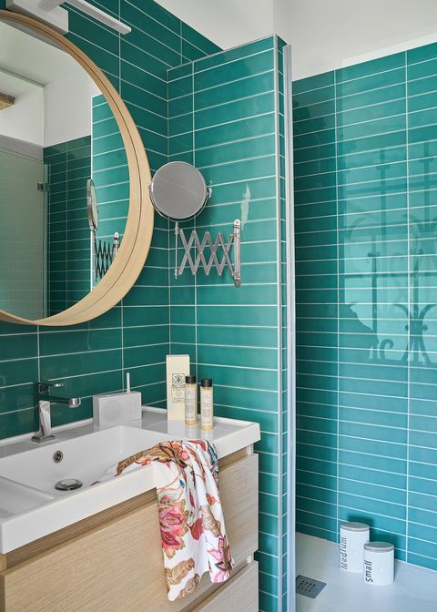 bathroom lined with turquoise subway tiles